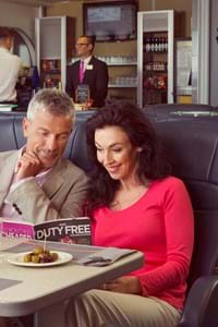 couple sitting and reading magazine in club class onboard condor rapide