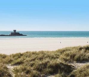 white sand and blue sea and sky at st Ouen's bay in jersey
