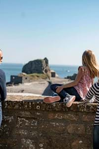 A family of 4 look out over Hermitage Rock from Elizabeth Castle in Jersey