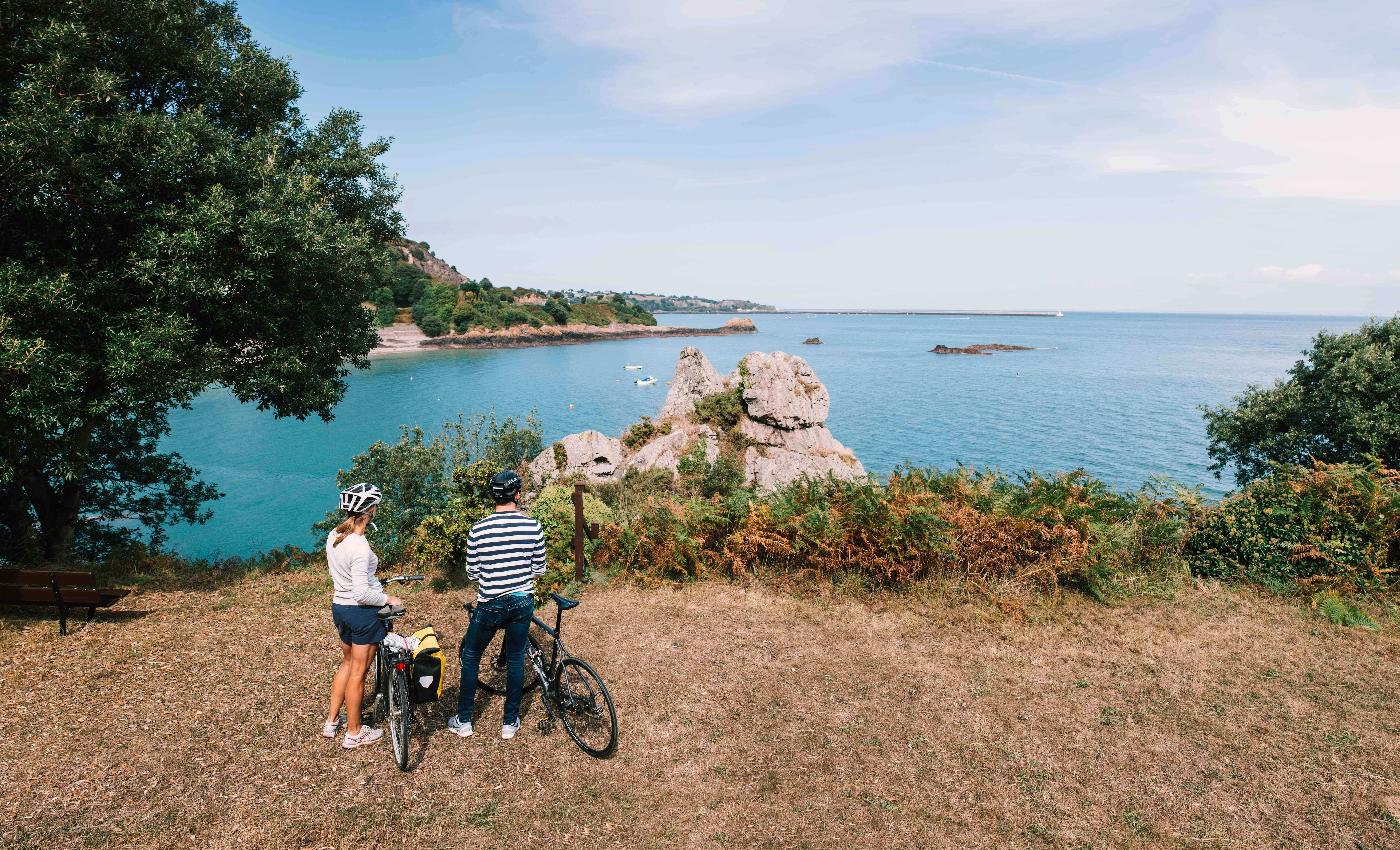 couple with bikes looking over jersey channel island sea