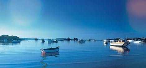 blue skies and sea with boats on the water in guernsey