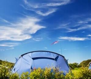 tent outside with blue sky and green grass guernsey channel islands