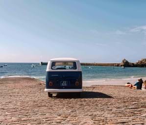 campervan on sandy beach looking over jersey sea