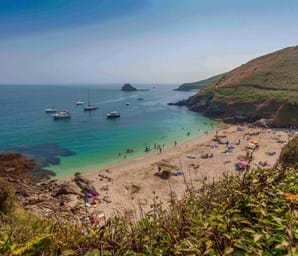 guernsey beach with grassy hills, white sand and blue sky