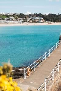 Looking back to shore across a jetty with views over the sea to the beach