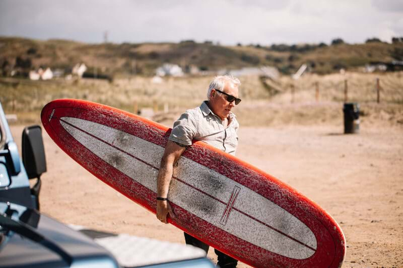 man walking with surfboard jersey channel islands