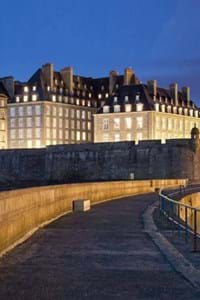 beautiful walls of st malo lit up at night with blue black sky in background