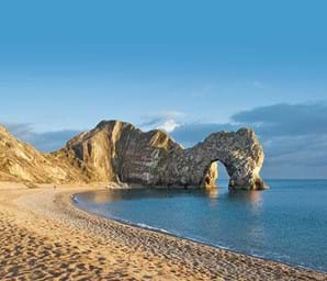 durdle door dorset with blue sea and golden sands