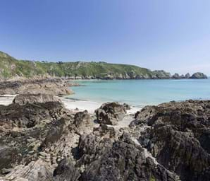 view of jagged rocks and blue sea in guernsey channel islands