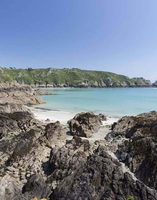 view of jagged rocks and blue sea in guernsey channel islands