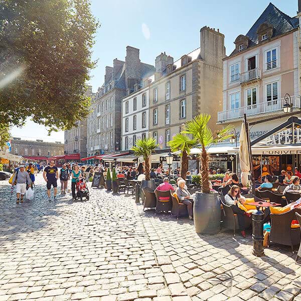 st malo street with people sitting outside eating in the sun