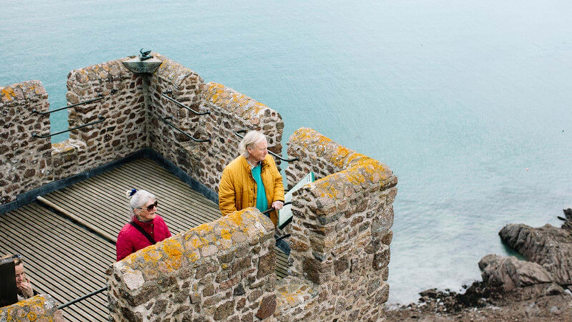 couple-looking-over-view-at-mont-orgueil-jersey-channel-islands