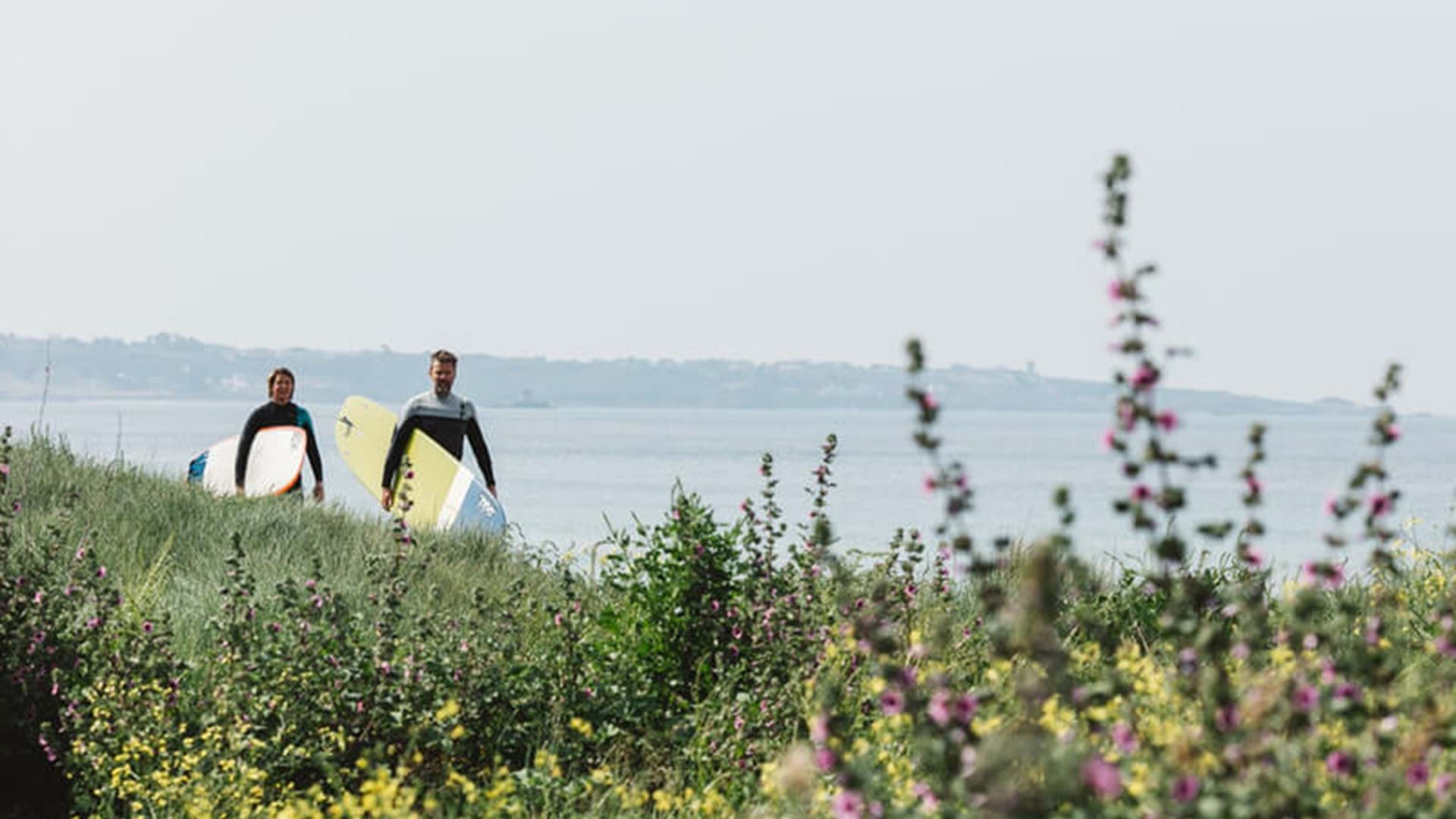 two-surfers-walking-in-st-ouens-bay-jersey